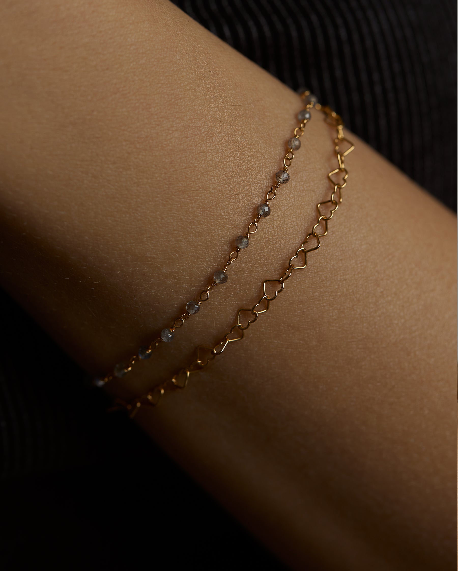 A closeup of a wrist, wearing the hearts double chain labradorite bracelet. It is made of silver and gold vermeil. Demi-fine jewelry. Made in Athens, Greece, Europe,EU.