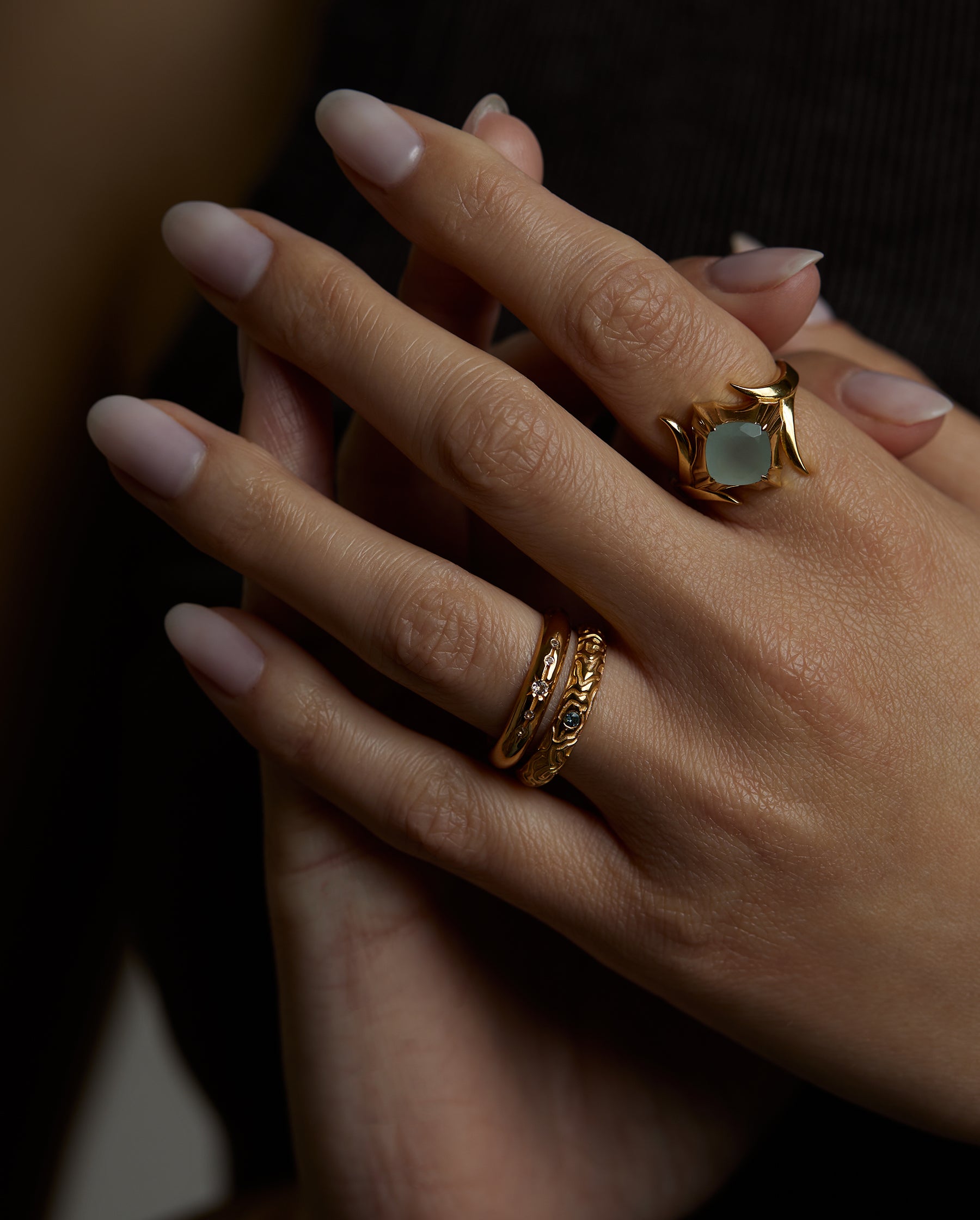 A closeup picture of a hand with three rings. The ascension ring with natural aquamarine gemstone and the light and shadow rings with natural topaz gemstones. All jewelry are made of silver and gold vermeil. Demi-fine jewelry. Made in Athens, Greece, Europe,EU.