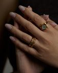 A closeup picture of a hand with three rings. The ascension ring with natural aquamarine gemstone and the light and shadow rings with natural topaz gemstones. All jewelry are made of silver and gold vermeil. Demi-fine jewelry. Made in Athens, Greece, Europe,EU.